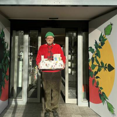 The gallery director Steffan, holding a box of food to be donated.